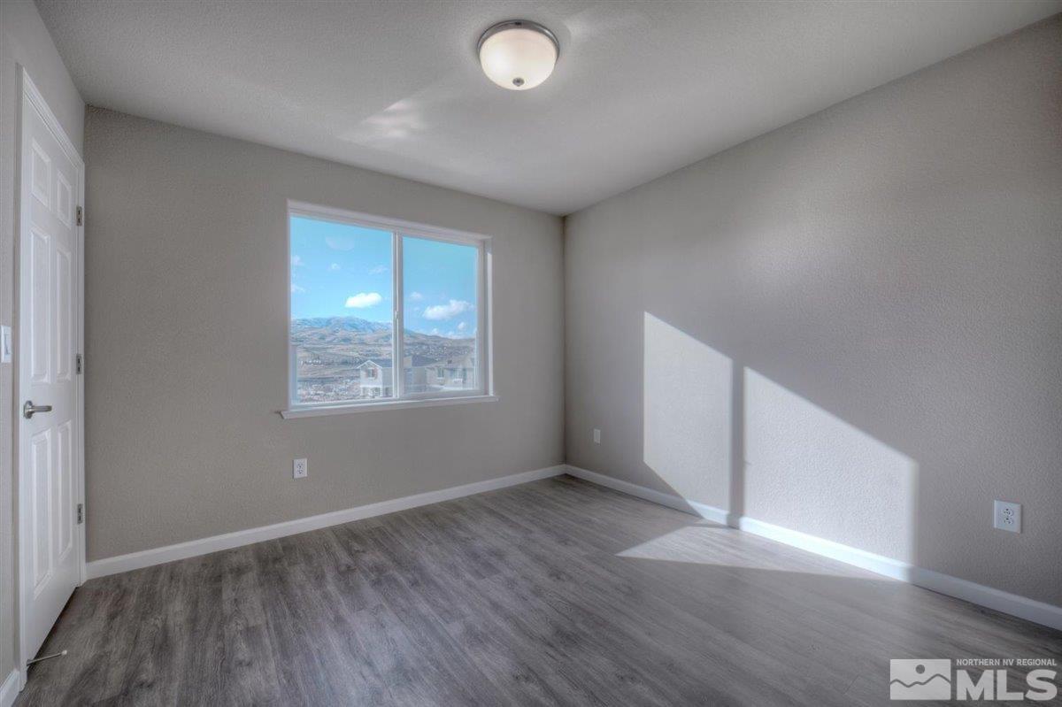 3408 Colonial Downs, Unit LOT 54 Reno, NV 89512 - Photo 20 of 26 an empty room with wooden floor and windows