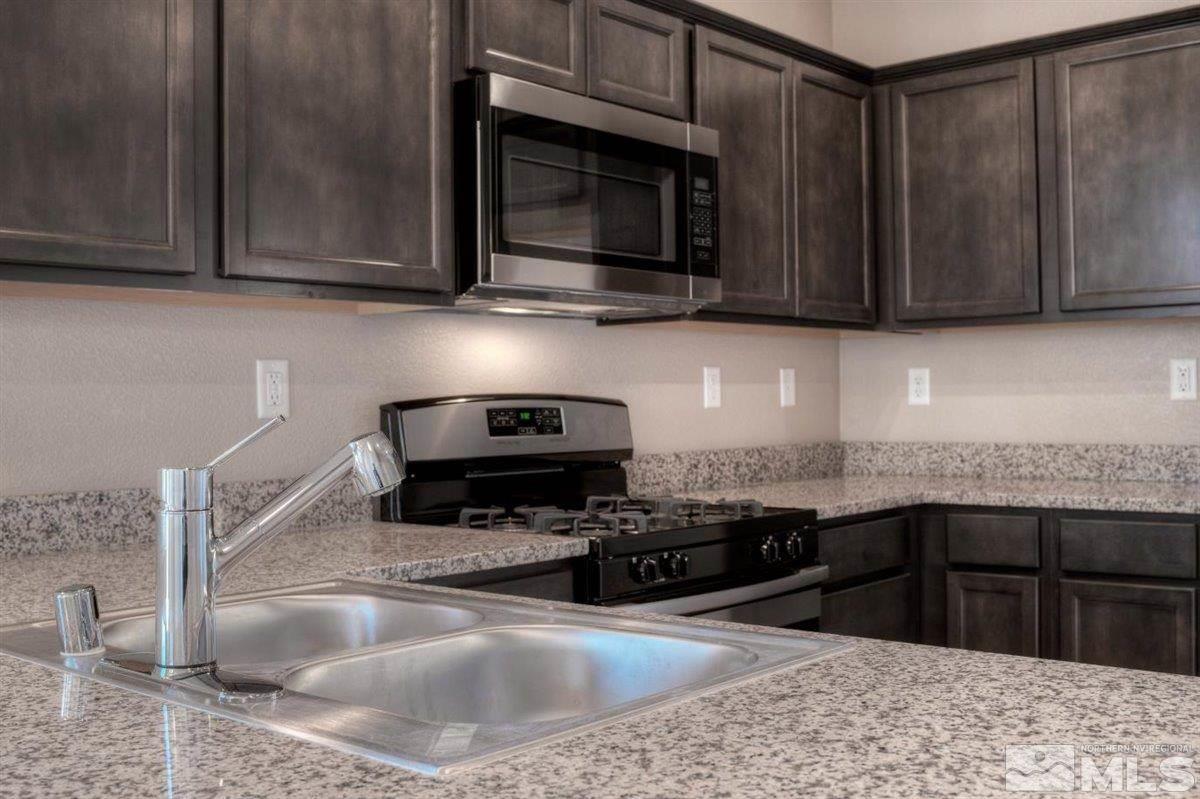 3408 Colonial Downs, Unit LOT 54 Reno, NV 89512 - Photo 8 of 26 a kitchen with stainless steel appliances granite countertop a sink stove and microwave