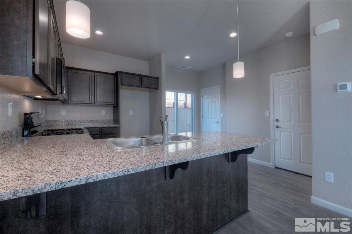 3408 Colonial Downs, Unit LOT 54 Reno, NV 89512 - Photo 9 of 26 a kitchen with stainless steel appliances granite countertop a sink stove and wooden floor