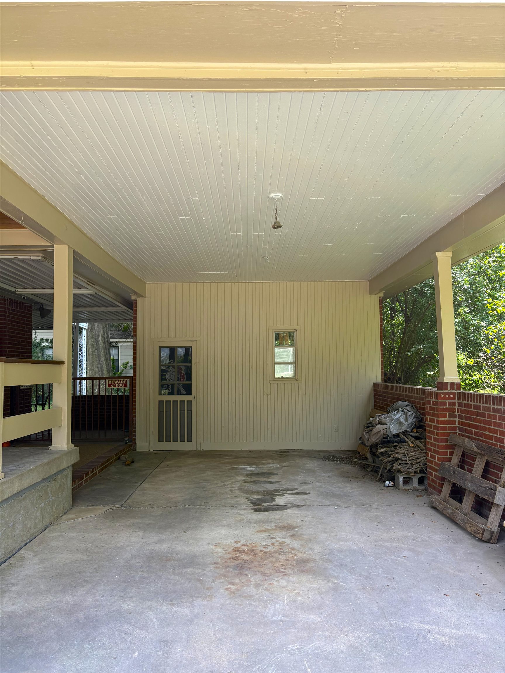 4651 Flamingo Road Memphis, TN 38117 - Photo 13 of 13 Covered porch featuring a beadboard ceiling, concrete flooring, and a beadboard wall with a window and a screen door