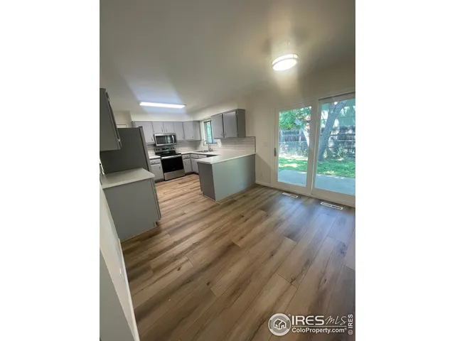 a view of a kitchen with furniture and wooden floor