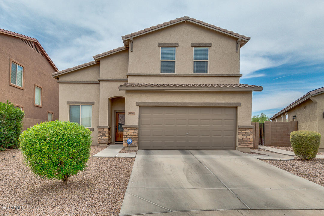 19216 North Lariat Road Maricopa, AZ 85138 - Photo 1 of 40 a front view of a house with a yard and garage