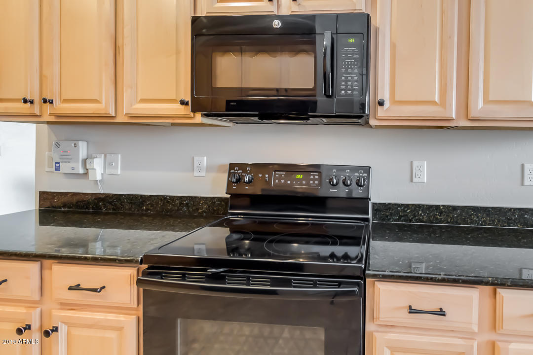19216 North Lariat Road Maricopa, AZ 85138 - Photo 15 of 40 a stove top oven sitting inside of a kitchen