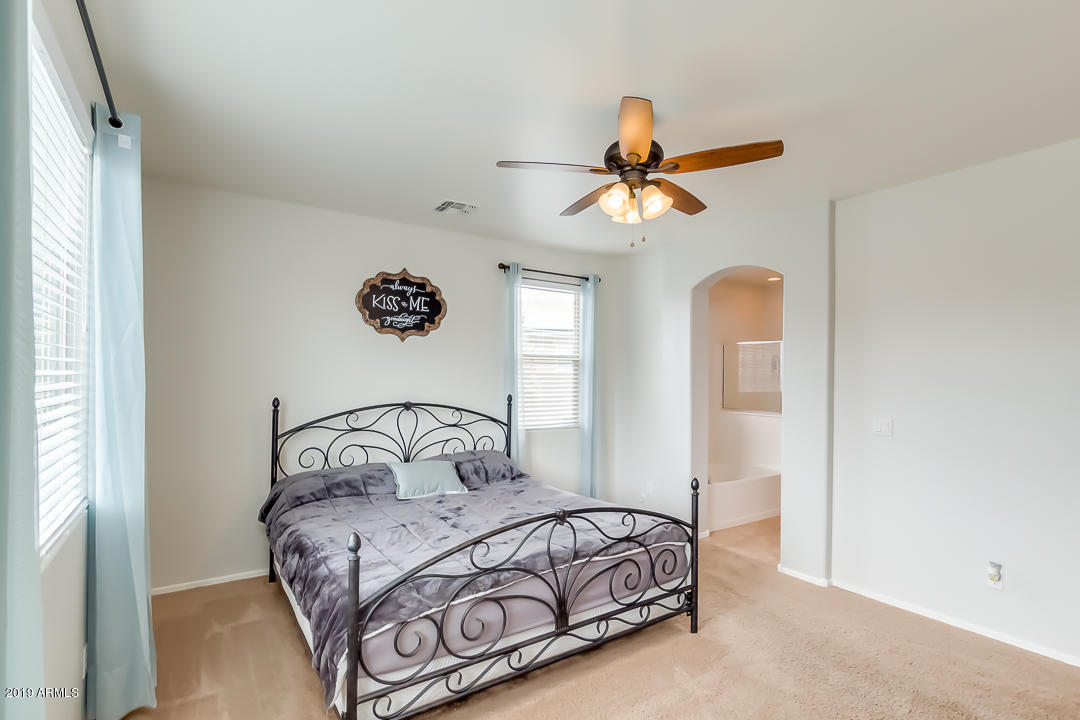 19216 North Lariat Road Maricopa, AZ 85138 - Photo 20 of 40 a bedroom with a bed and a chandelier