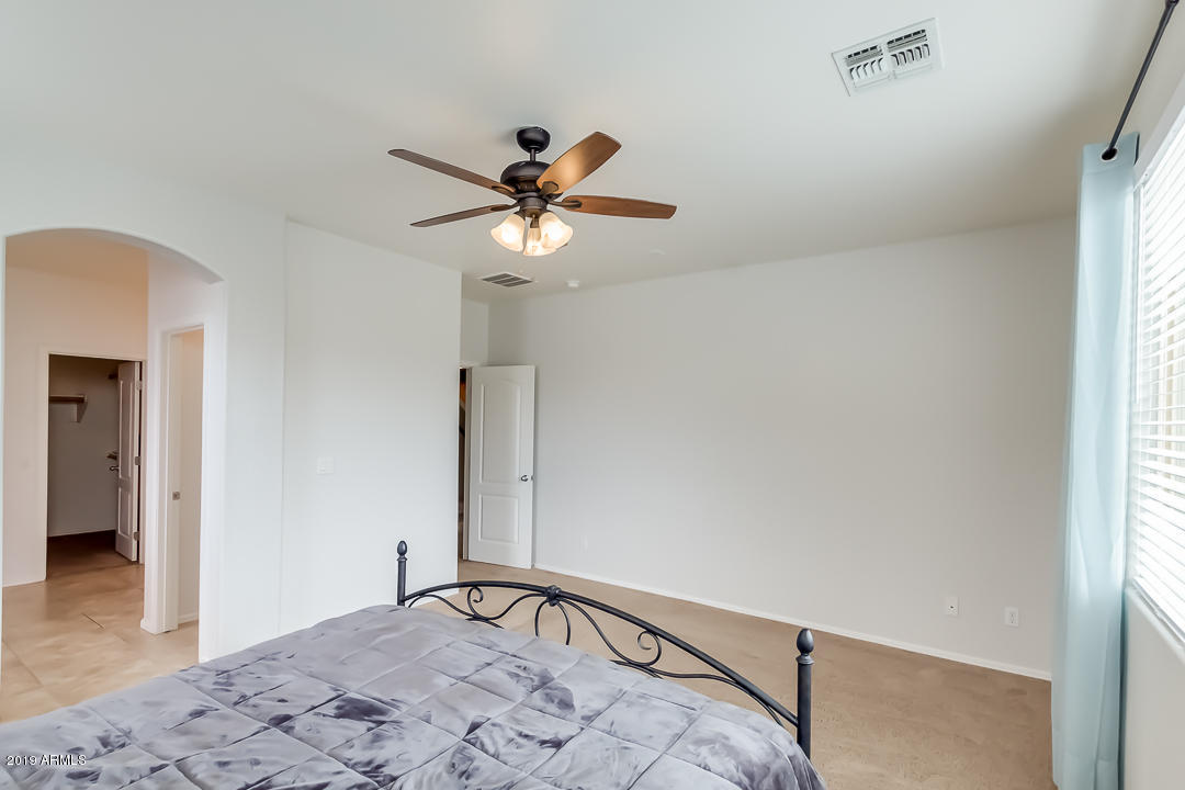 19216 North Lariat Road Maricopa, AZ 85138 - Photo 21 of 40 a bedroom with a bed and a window