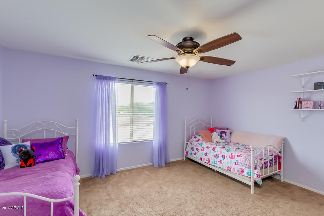 19216 North Lariat Road Maricopa, AZ 85138 - Photo 29 of 40 a bedroom with a bed and a chandelier