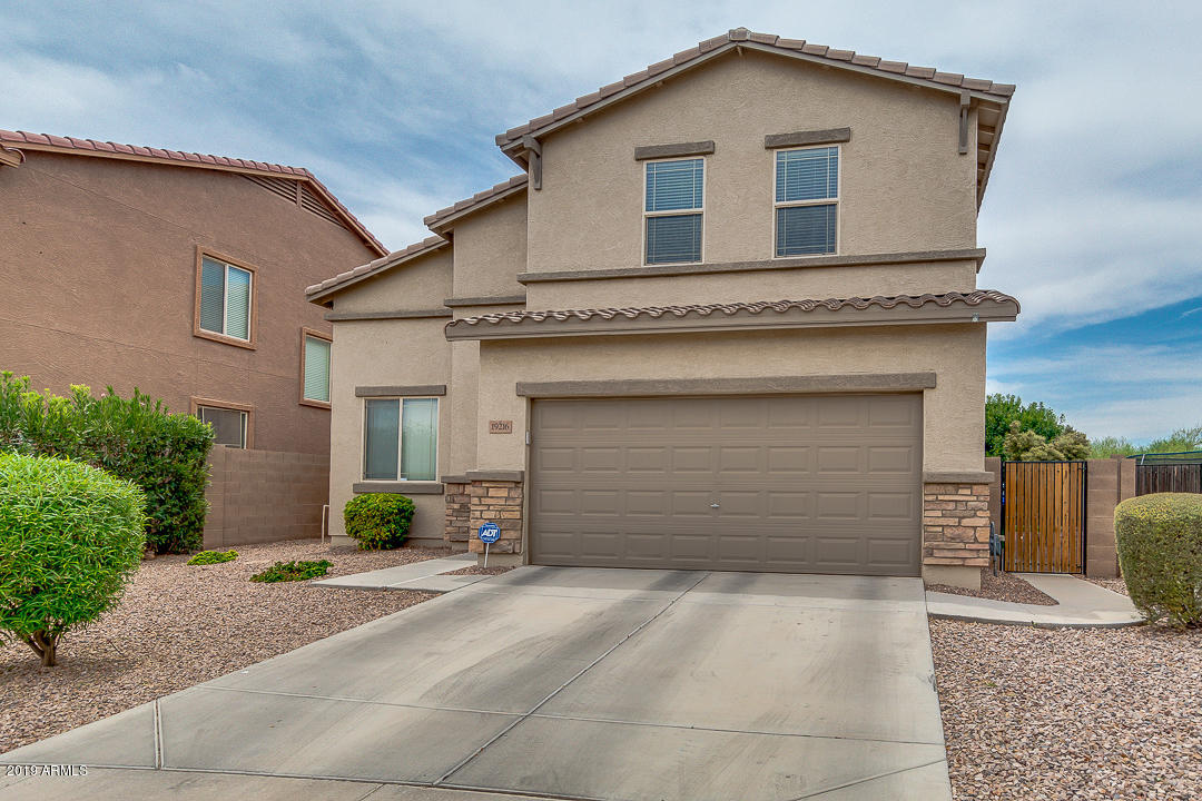 19216 North Lariat Road Maricopa, AZ 85138 - Photo 3 of 40 a front view of a house with a yard and garage