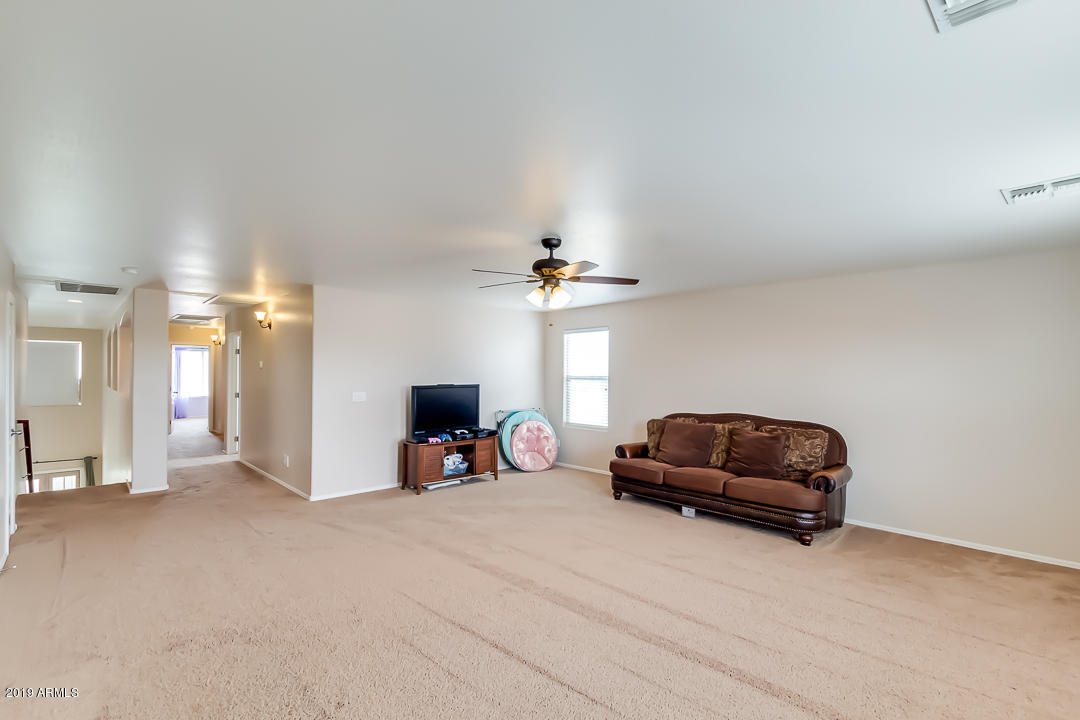 19216 North Lariat Road Maricopa, AZ 85138 - Photo 10 of 40 a living room with furniture a flat screen tv and a window