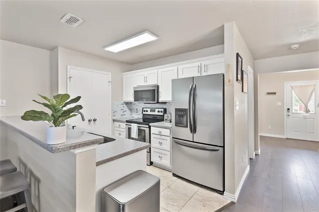 a kitchen with white cabinets and white stainless steel appliances