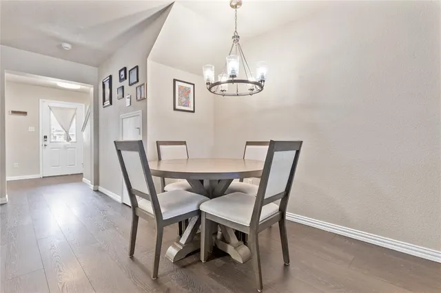 a view of a dining room with furniture a chandelier and wooden floor