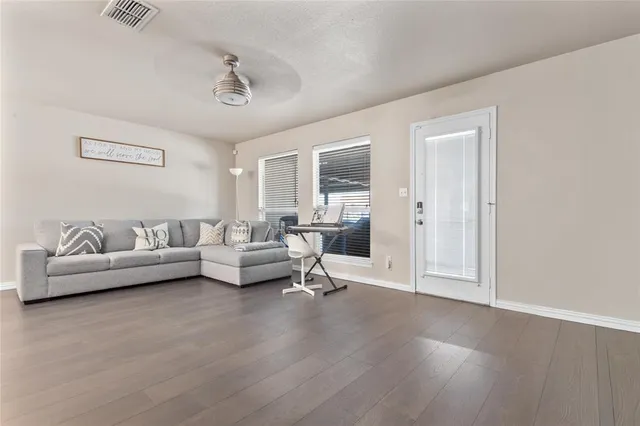 a living room with furniture and a wooden floor