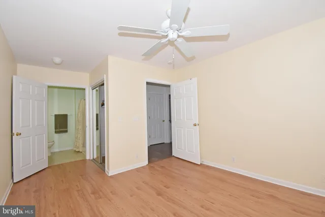 an empty room with a window and a fan
