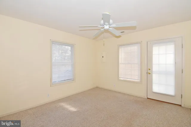 an empty room with a ceiling fan and a window
