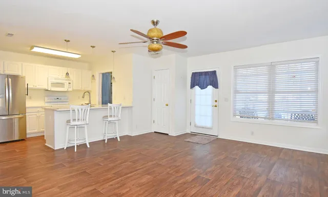 a view of a kitchen with wooden floor and a window