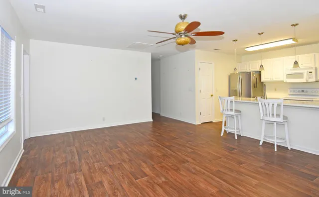 a view of a kitchen with wooden floor and a ceiling fan