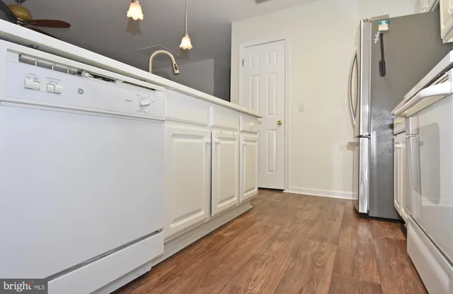 a view of a utility room with closet and wooden floor