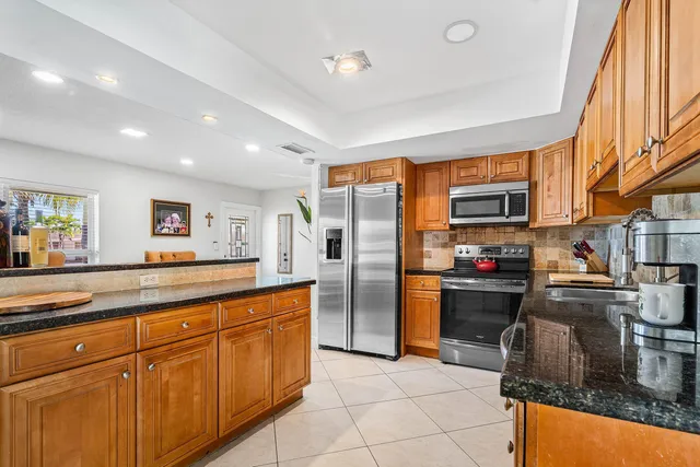 a kitchen with stainless steel appliances granite countertop a sink stove and refrigerator