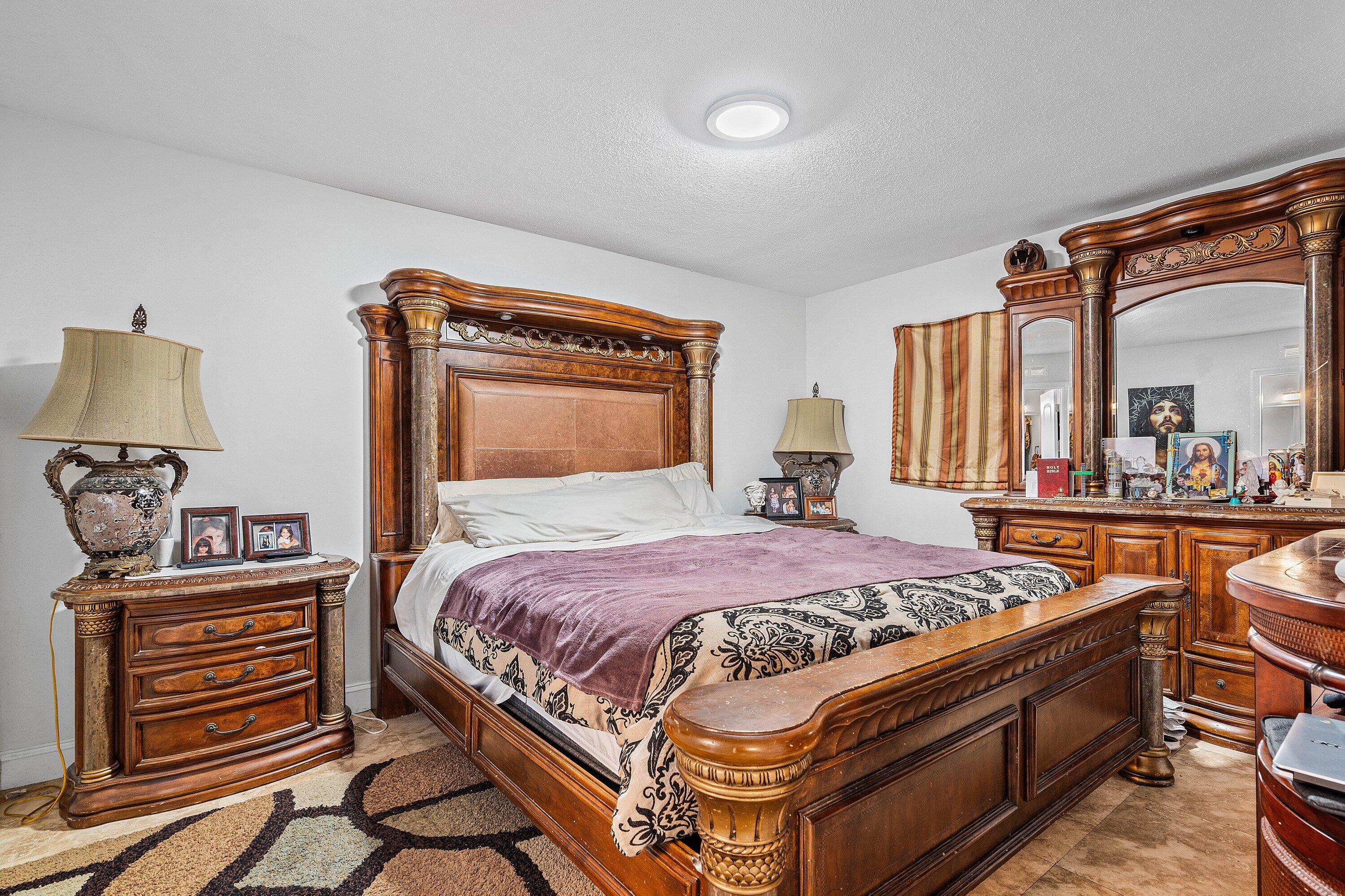 22207 Southwest 65th Terrace Boca Raton, FL 33428 - Photo 17 of 27 a bedroom with a bed and a dresser in it