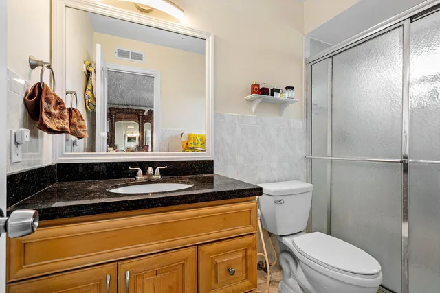 a bathroom with a granite countertop toilet sink and shower