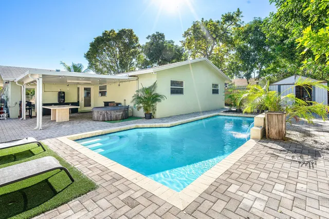 a view of a house with pool fire pit a patio and swimming pool