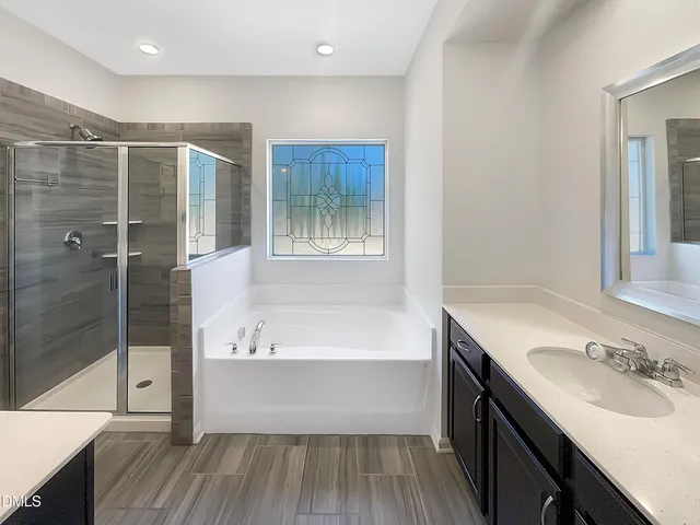 a bathroom with a tub sink and shower