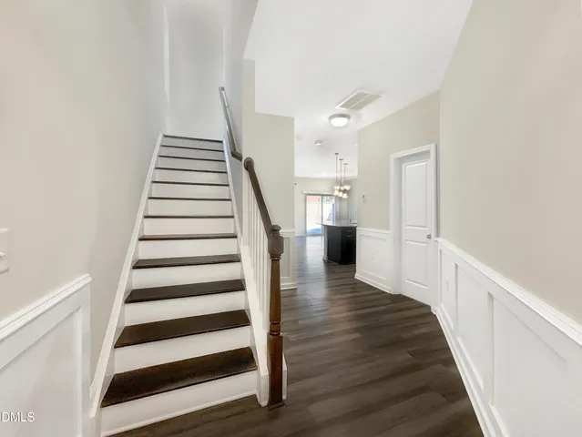 a view of a hallway with wooden floor and stairs