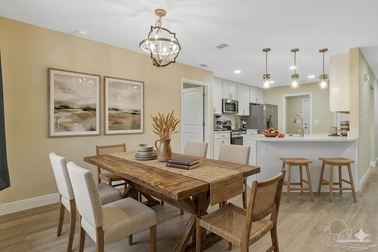 295 West Kingsfield Road Cantonment, FL 32533 - Photo 2 of 47 a view of a dining room with furniture and wooden floor