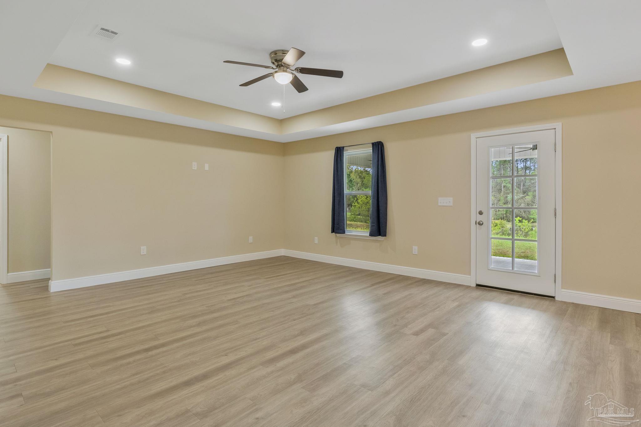 295 West Kingsfield Road Cantonment, FL 32533 - Photo 5 of 47 a view of an empty room with wooden floor and a window
