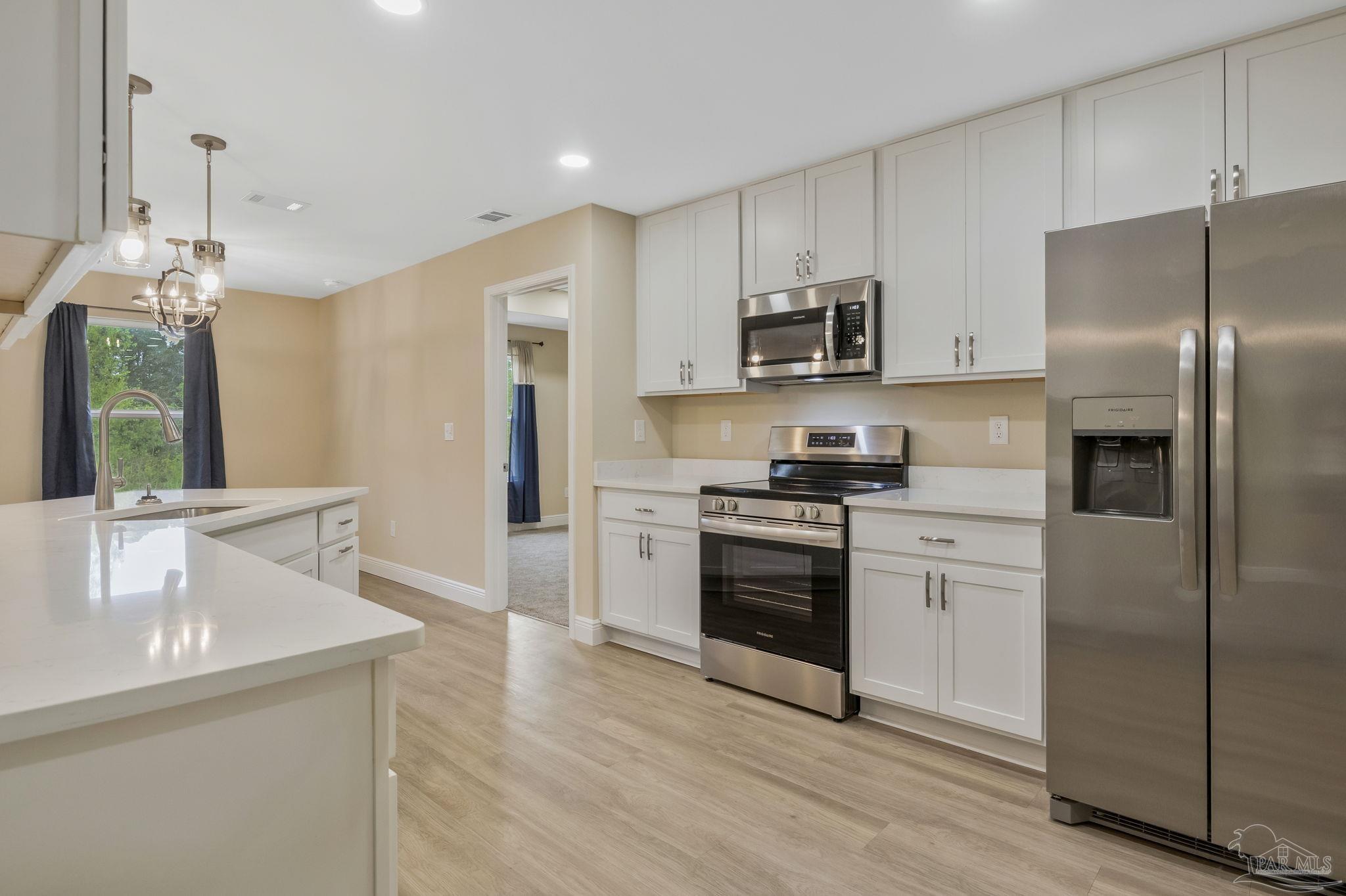 295 West Kingsfield Road Cantonment, FL 32533 - Photo 9 of 47 a kitchen with stainless steel appliances a refrigerator sink and microwave