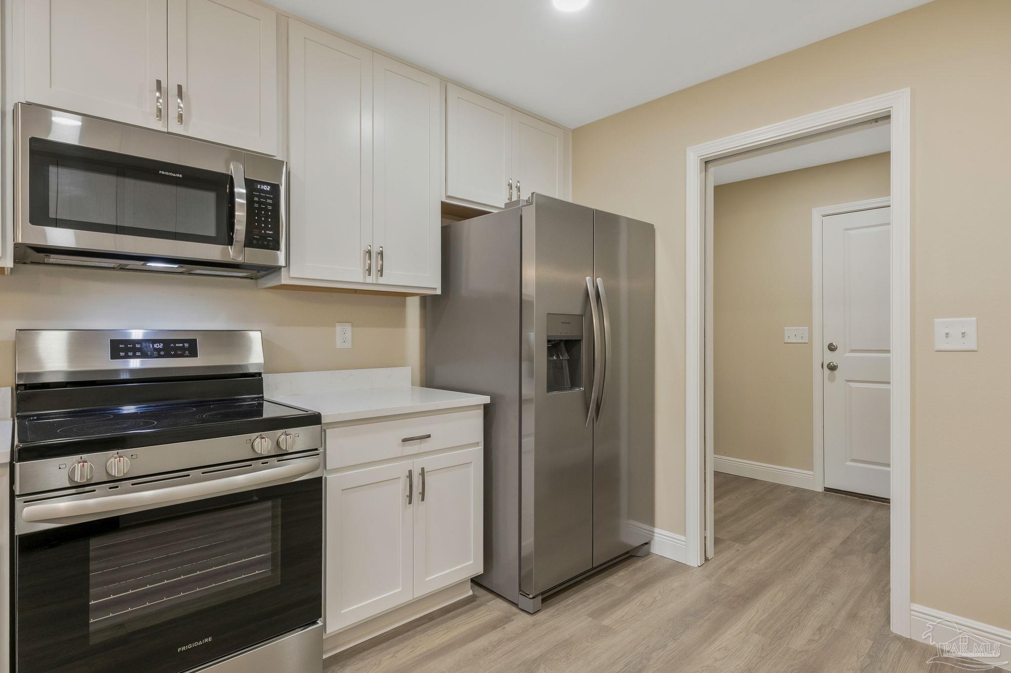 295 West Kingsfield Road Cantonment, FL 32533 - Photo 10 of 47 a kitchen with stainless steel appliances a refrigerator microwave and sink