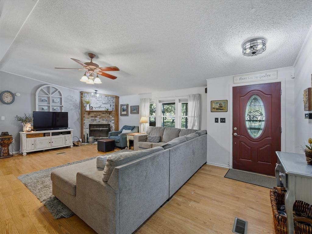3275 Finis Road Graham, TX 76450 - Photo 6 of 36 a living room with furniture a flat screen tv and a fireplace