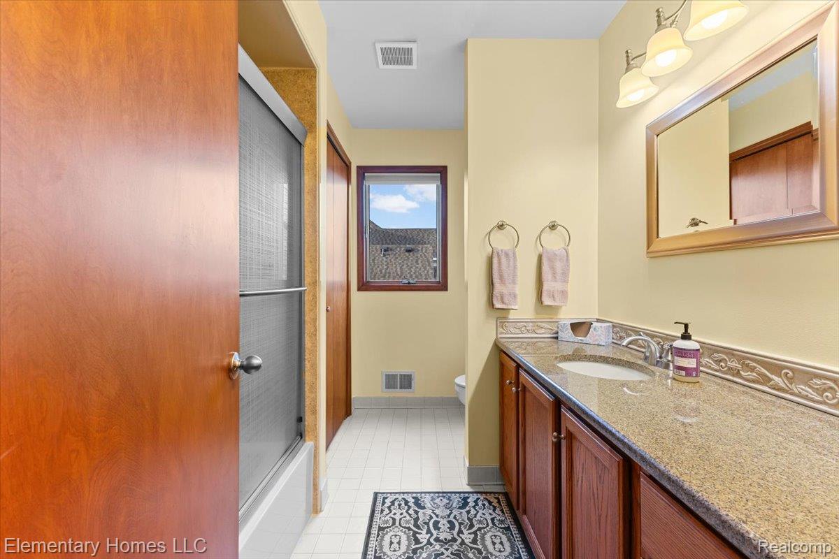 51637 Baker Road New Baltimore, MI 48047 - Photo 33 of 47 Bathroom with vanity, bath / shower combo with glass door, and light tile patterned floors