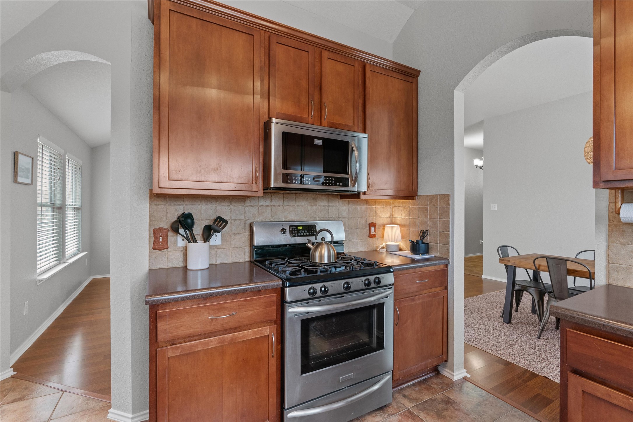 1587 Haynie Bend Round Rock, TX 78665 - Photo 11 of 25 a kitchen with granite countertop wooden cabinets stainless steel appliances and a window