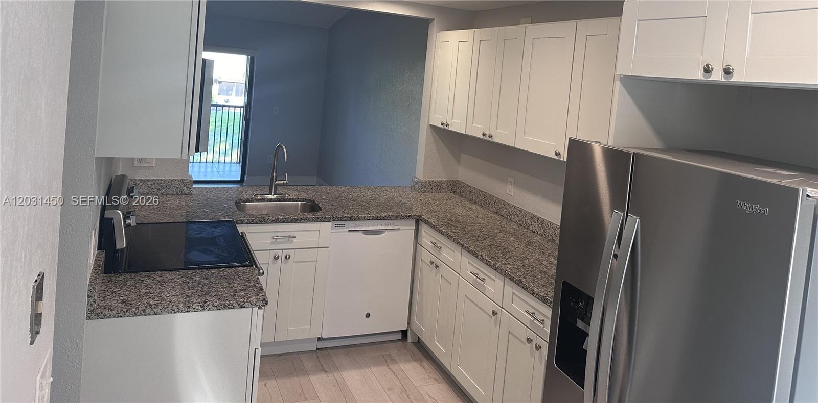23398 Lyons Road, Unit 309 Boca Raton, FL 33428 - Photo 11 of 16 a kitchen with granite countertop a refrigerator sink and stove