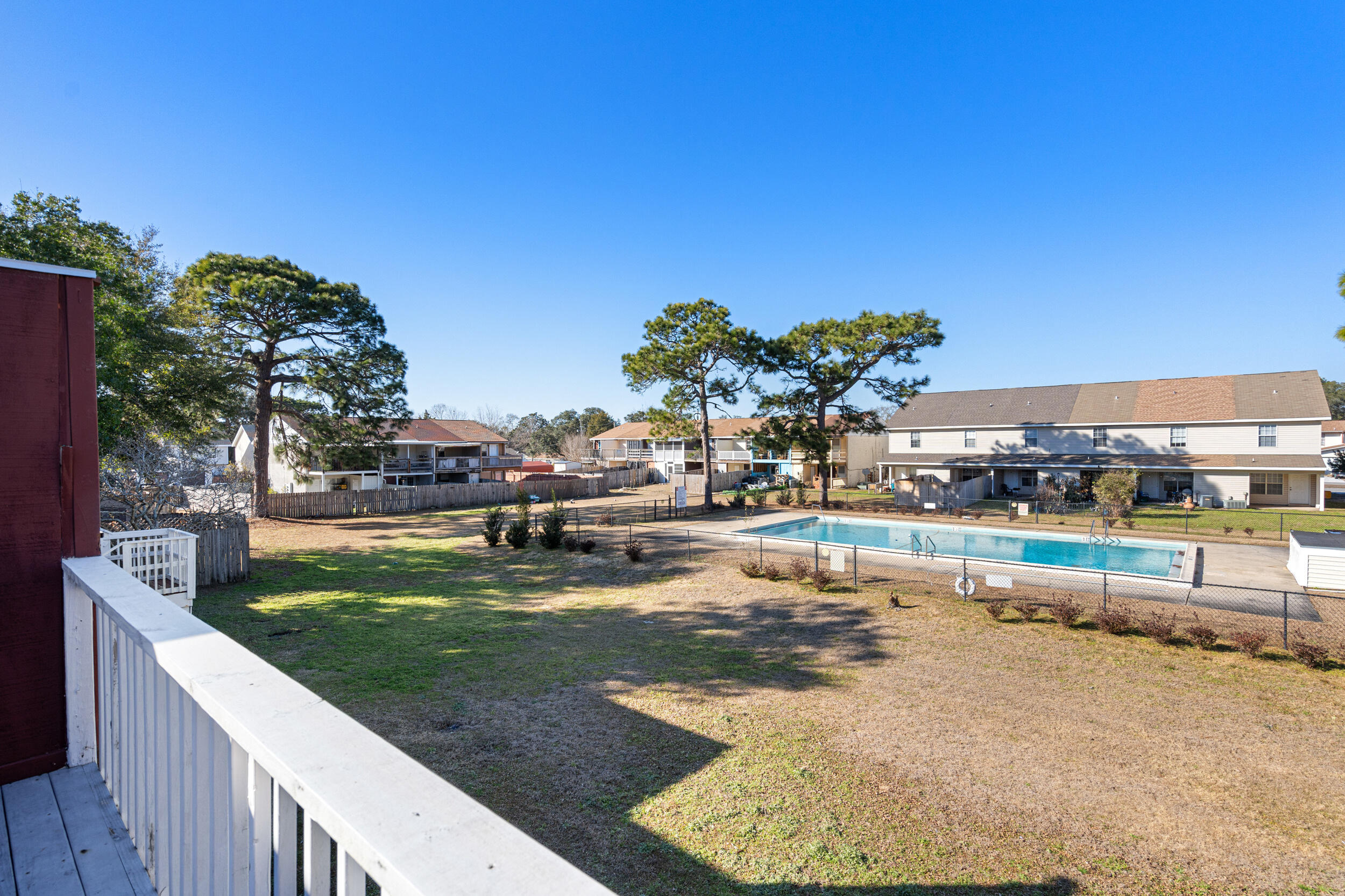 145 4th Avenue, Unit C2 Shalimar, FL 32579 - Photo 20 of 35 a view of a swimming pool with a lawn chairs and plants