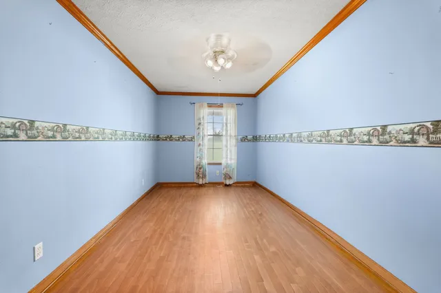 a view of a big room with wooden floor and windows