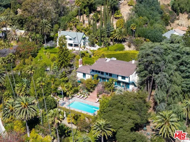 an aerial view of residential houses with outdoor space and trees