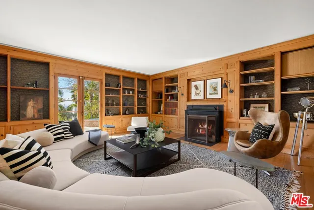 a living room with furniture a fireplace and a large window