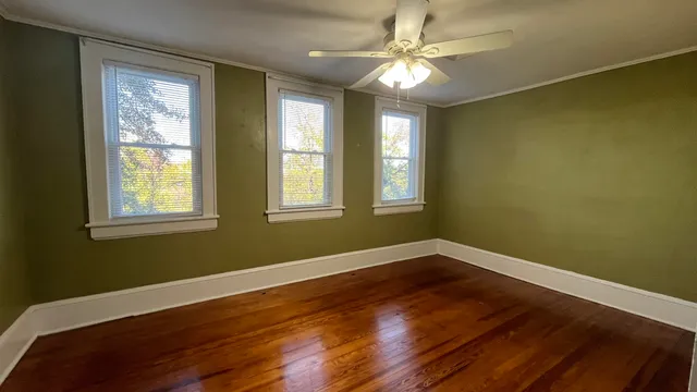 a view of an empty room with wooden floor