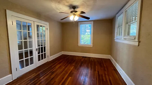 a view of empty room with a window and wooden floor