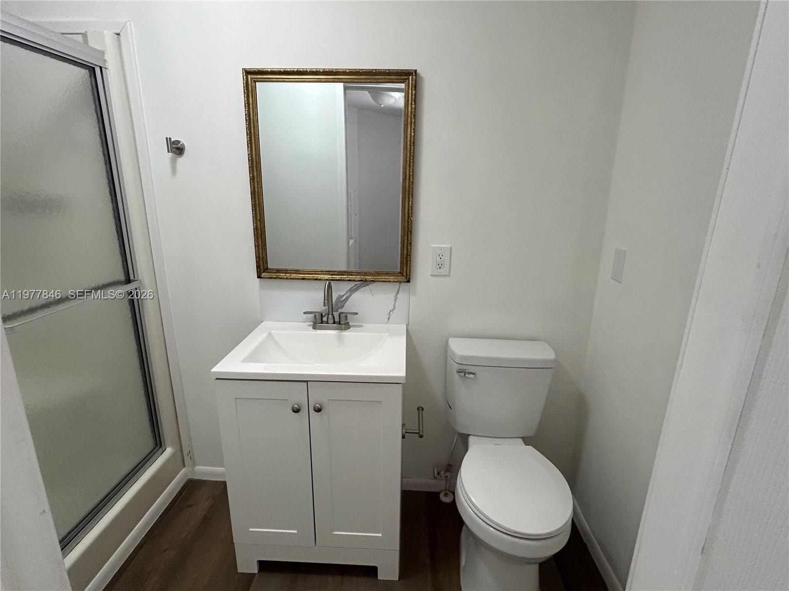 10467 South 228th Lane, Unit A Boca Raton, FL 33428 - Photo 13 of 27 a bathroom with a toilet sink and mirror