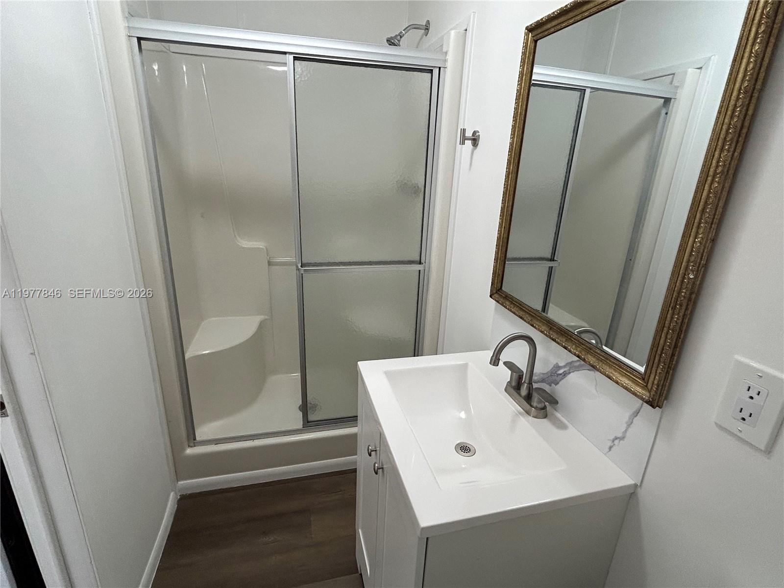 10467 South 228th Lane, Unit A Boca Raton, FL 33428 - Photo 14 of 27 a bathroom with a sink a mirror and shower