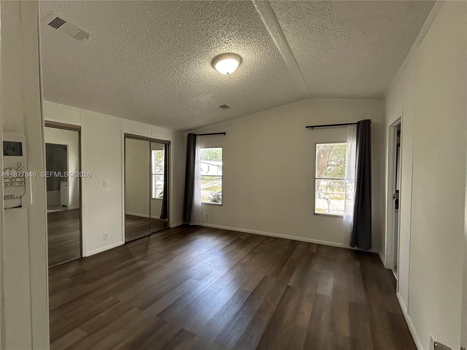 10467 South 228th Lane, Unit A Boca Raton, FL 33428 - Photo 15 of 27 a view of an empty room with wooden floor and a window