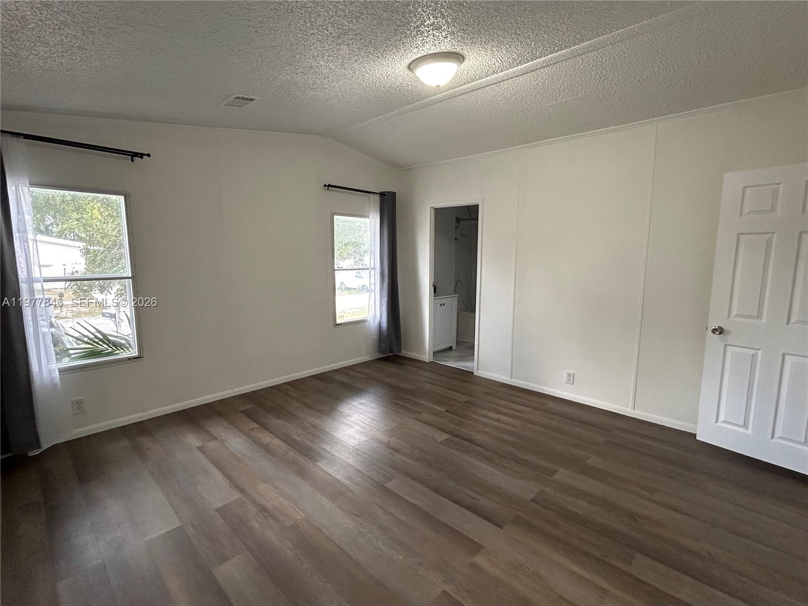 10467 South 228th Lane, Unit A Boca Raton, FL 33428 - Photo 16 of 27 an empty room with wooden floor and windows