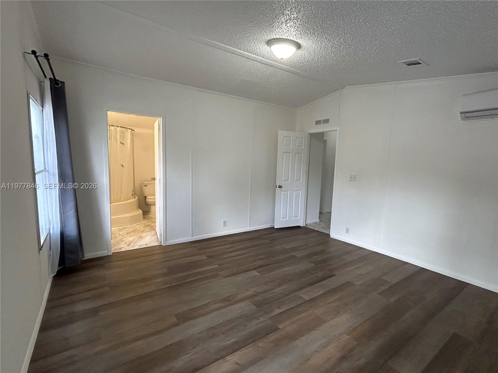 10467 South 228th Lane, Unit A Boca Raton, FL 33428 - Photo 18 of 27 a view of an empty room with wooden floor and a window
