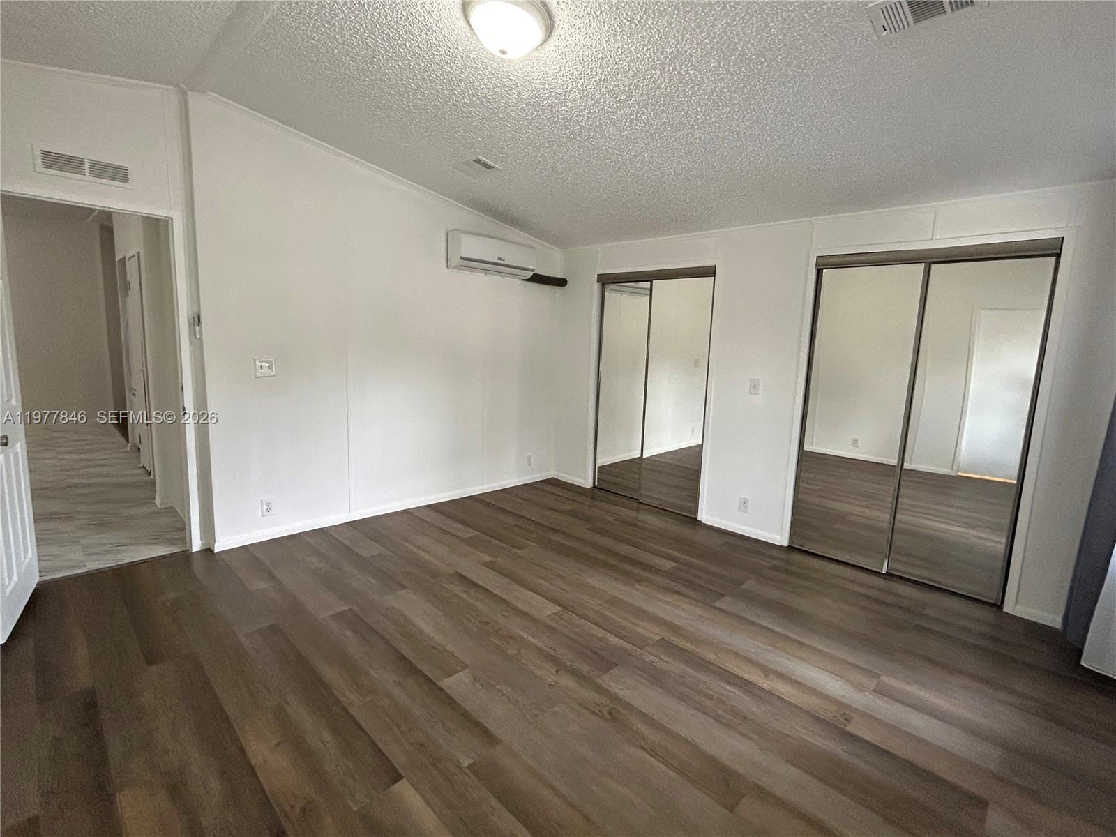10467 South 228th Lane, Unit A Boca Raton, FL 33428 - Photo 19 of 27 an empty room with wooden floor and mirror