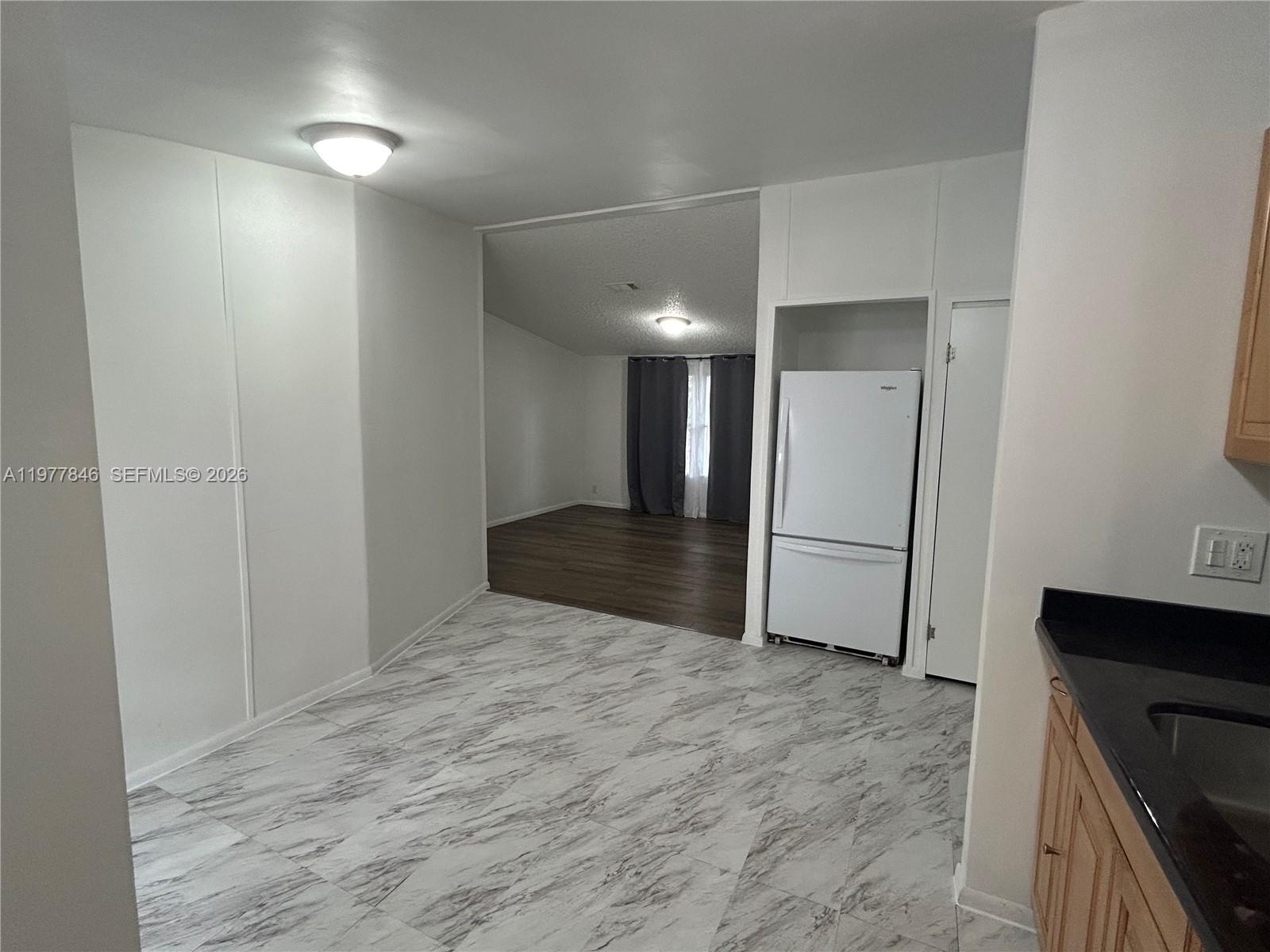 10467 South 228th Lane, Unit A Boca Raton, FL 33428 - Photo 4 of 27 a view of a refrigerator in kitchen and an empty room