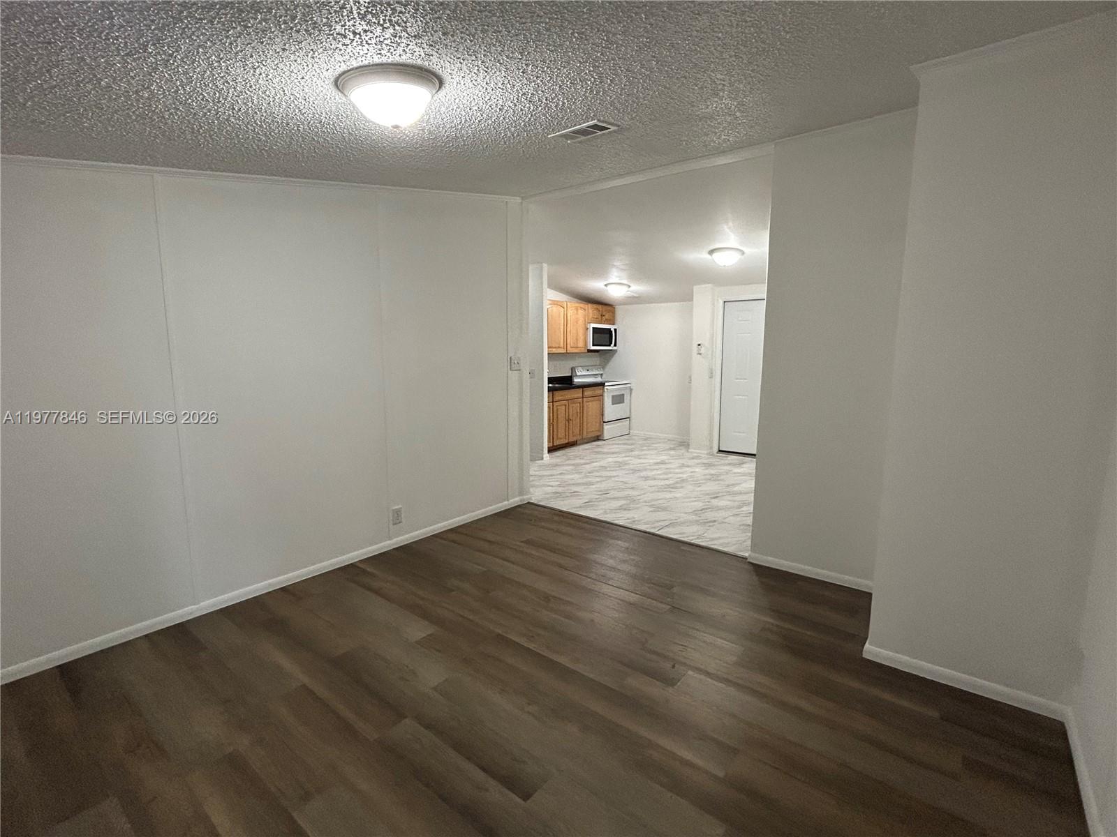 10467 South 228th Lane, Unit A Boca Raton, FL 33428 - Photo 9 of 27 an empty room with wooden floor and windows