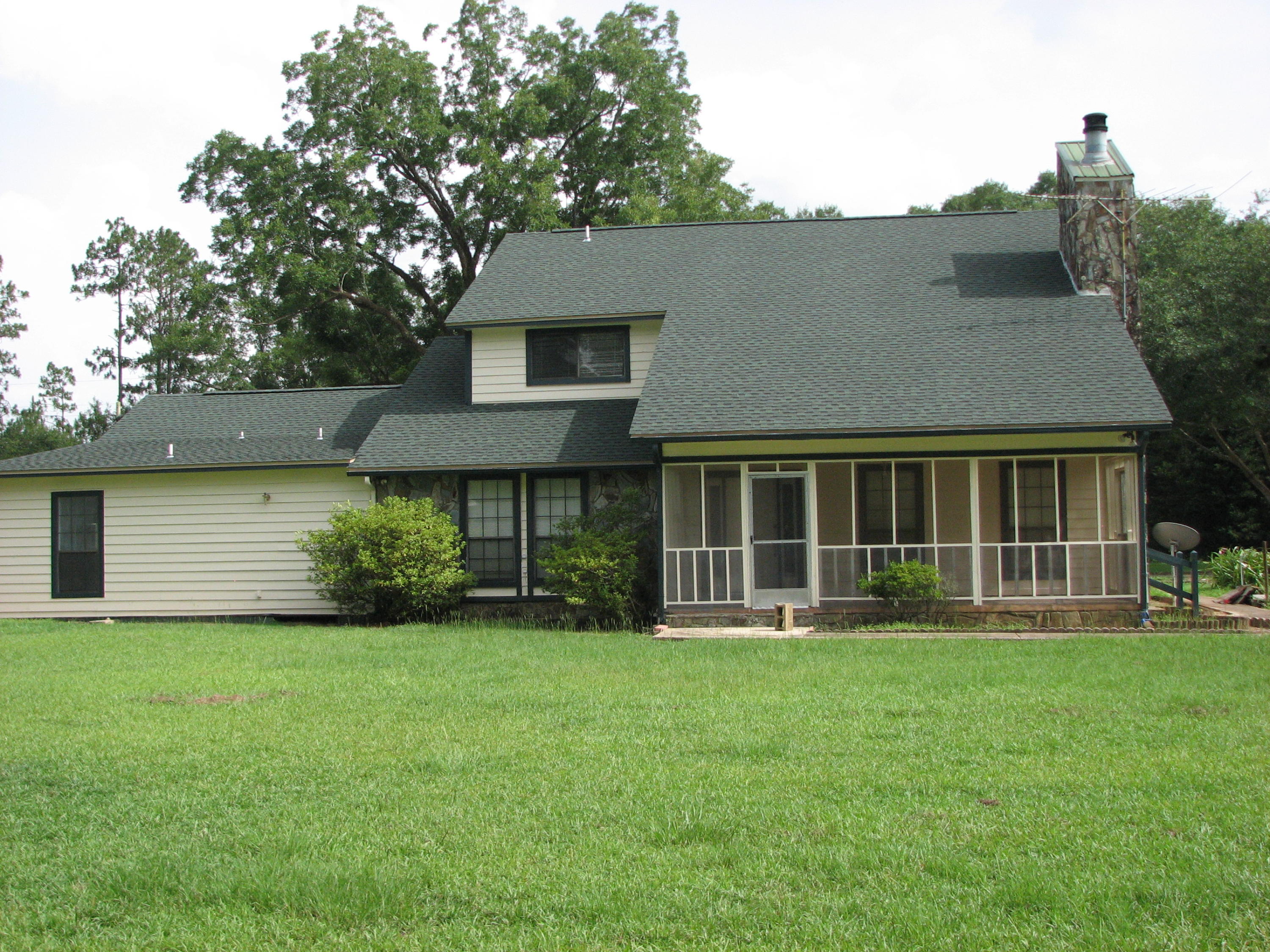 803 Melton Road Baker, FL 32531 - Photo 3 of 36 a front view of a house with a yard and trees