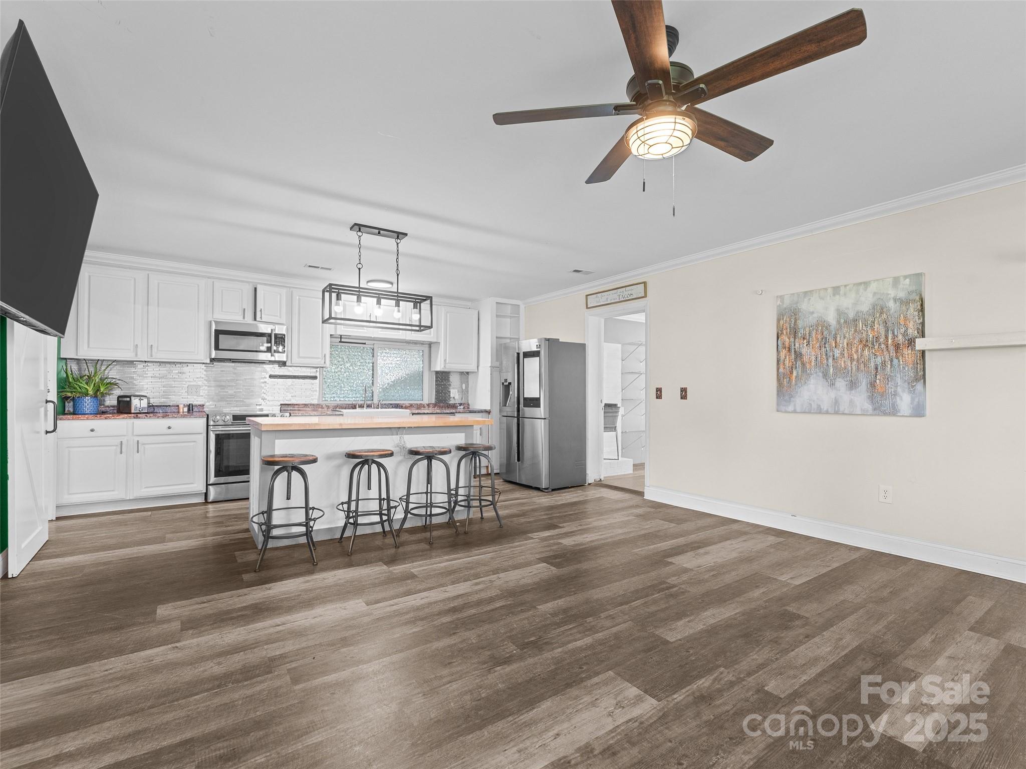 1148 North Ridge Road Hendersonville, NC 28792 - Photo 6 of 42 a kitchen with kitchen island stainless steel appliances a dining table chairs and a refrigerator